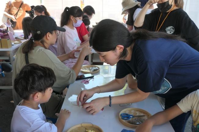 學生協助孩童製作端午香包